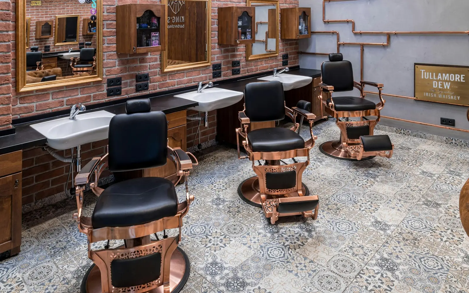 Interior de barbearia com várias cadeiras e espelhos.