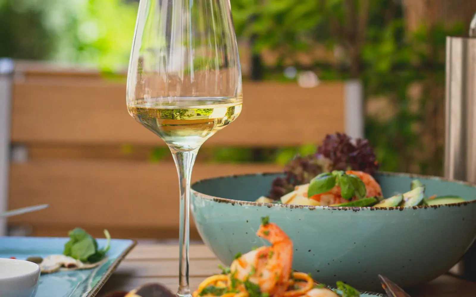 Prato de comida e um copo de vinho.